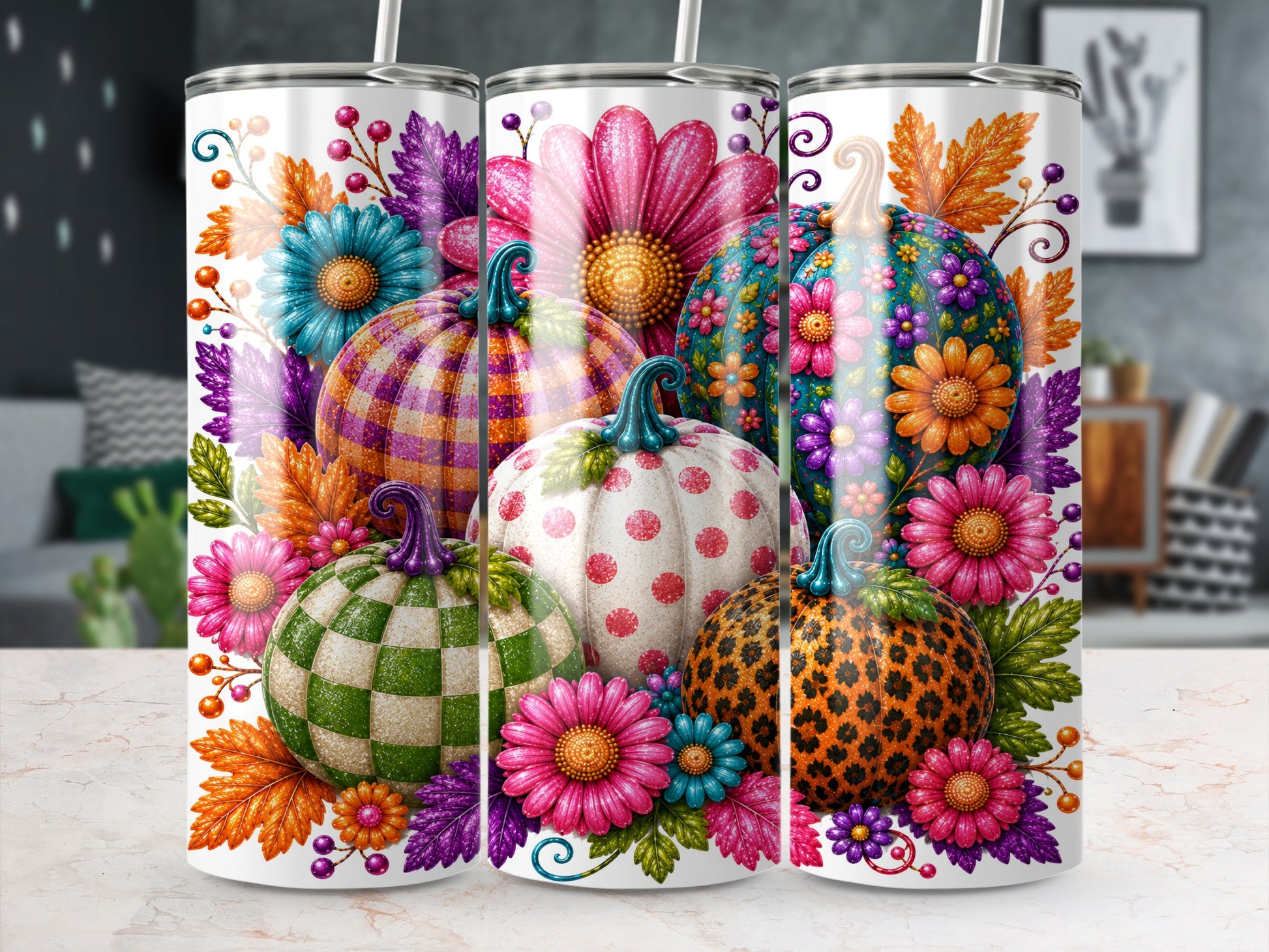 Three tumblers decorated with colorful pumpkins, flowers, and autumn leaves.