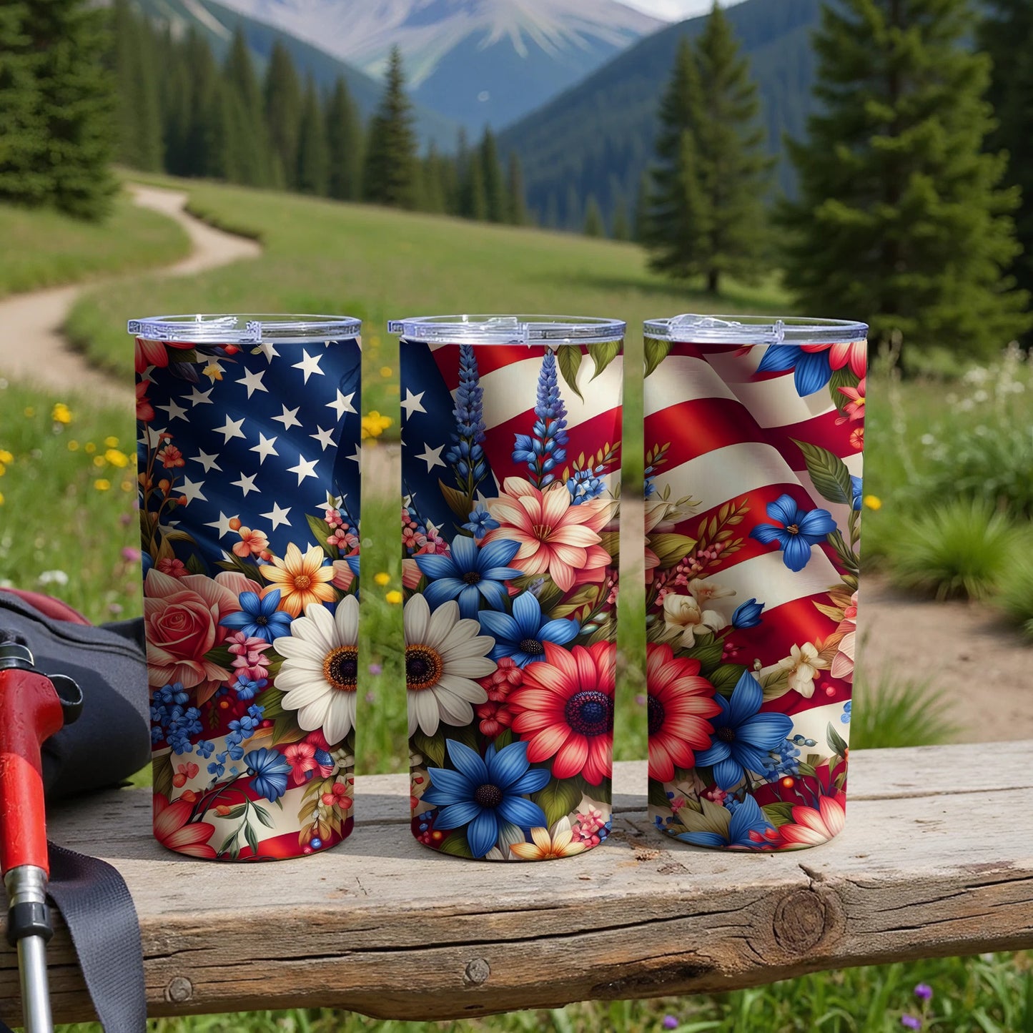 Three tumblers with patriotic floral designs on a wooden surface.