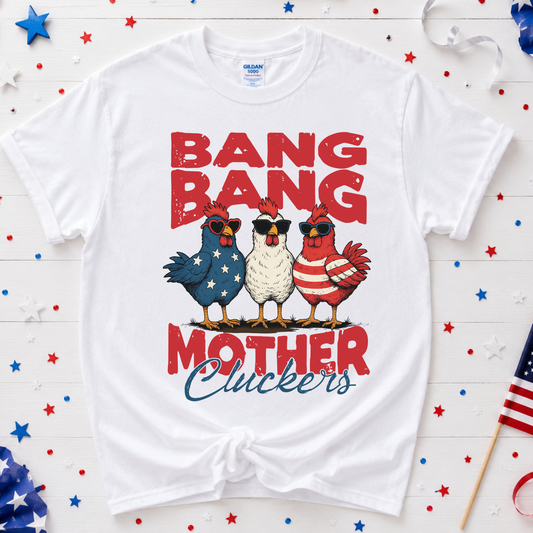 White t-shirt with 'Bang Bang Mother Cluckers' graphic on a wooden background with stars and an American flag.