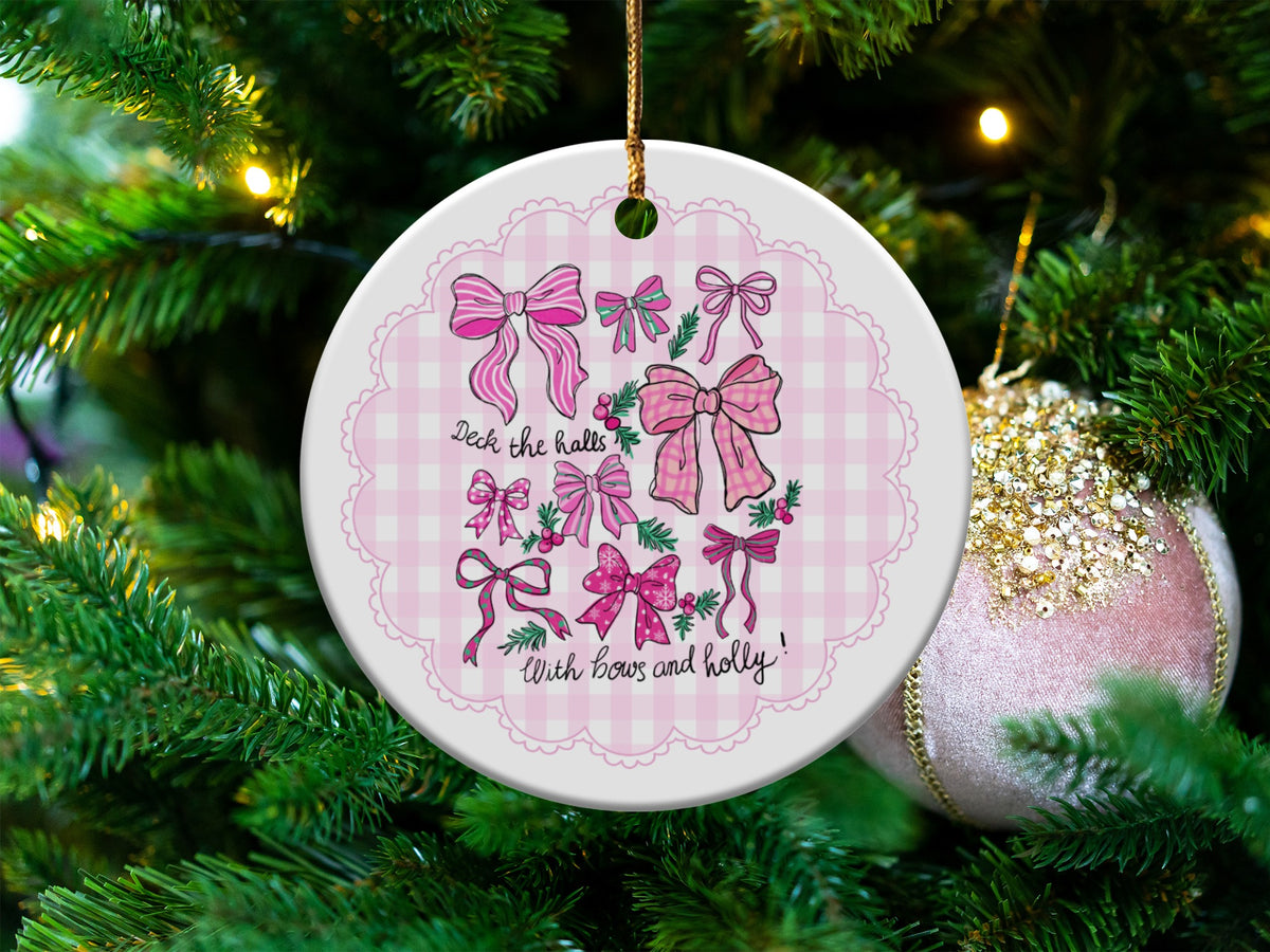 Round ceramic ornament with pink bows and text "Deck the halls With bows and holly".
