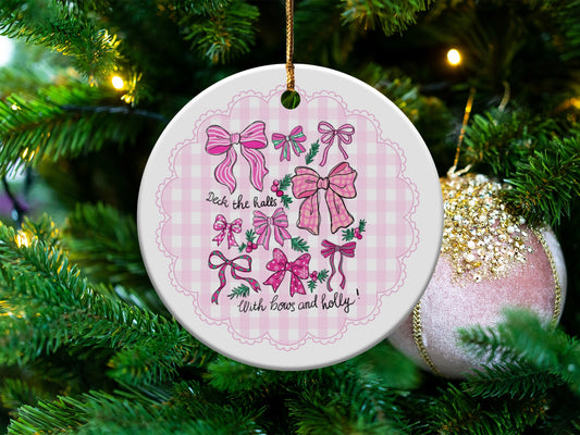 Round ceramic ornament with pink bows and text "Deck the halls With bows and holly".