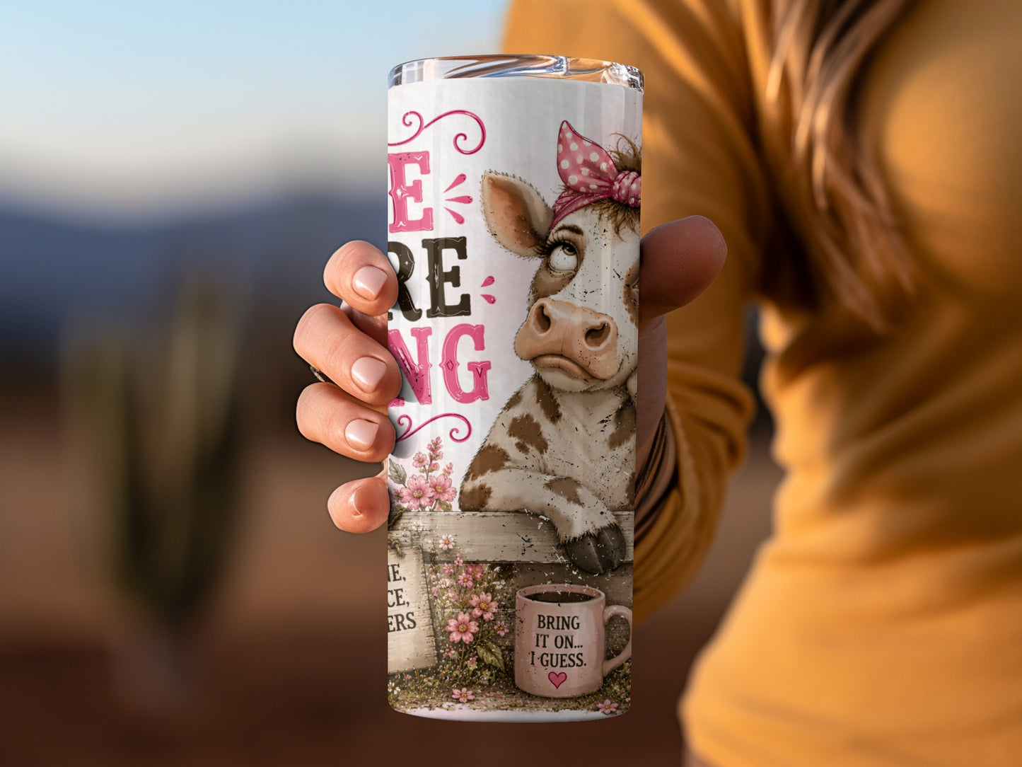Tumbler with a cow wearing a pink bow on its head and the text "BEING..."
