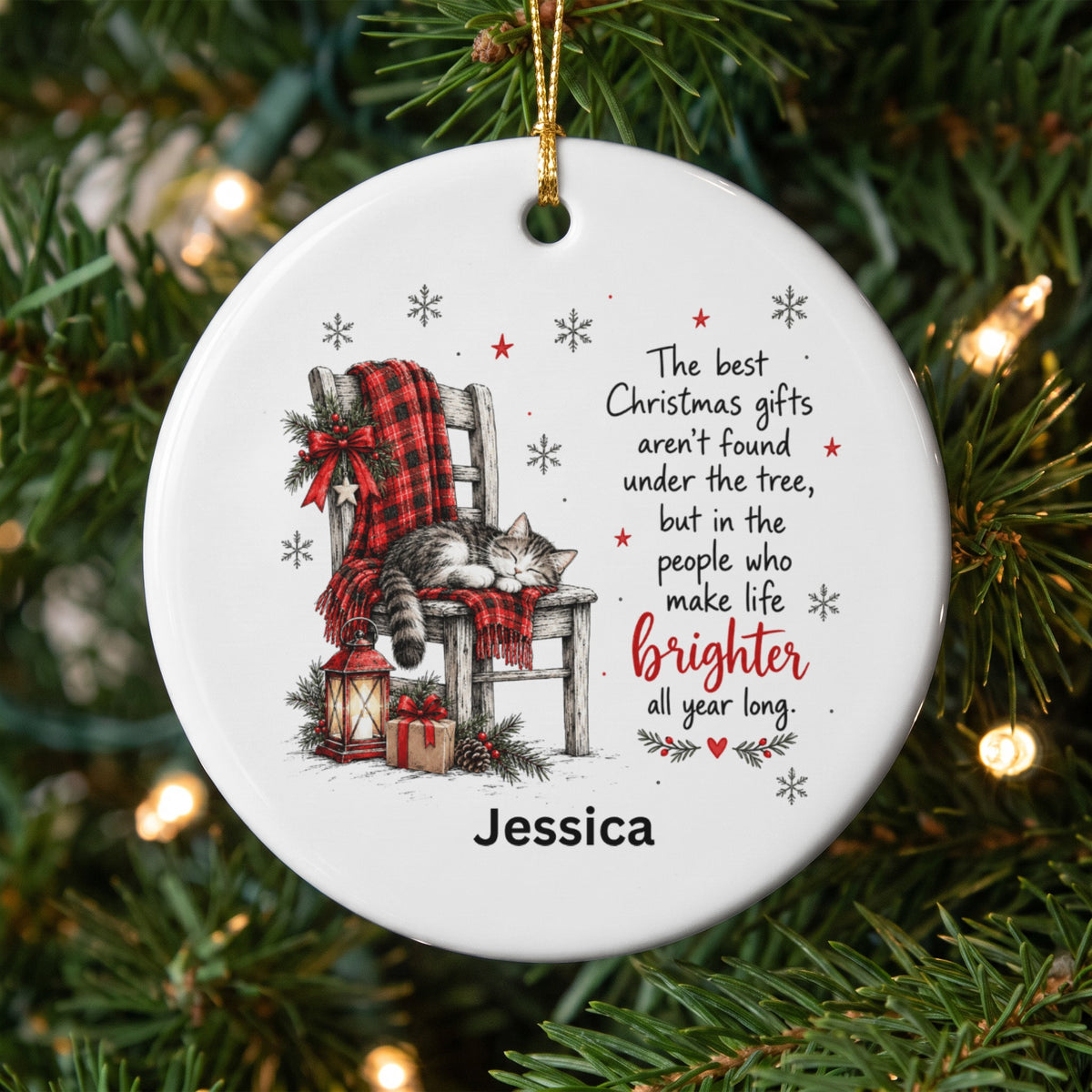 A round ceramic Christmas ornament featuring a sleeping cat on a chair, holiday text, and the name Jessica.