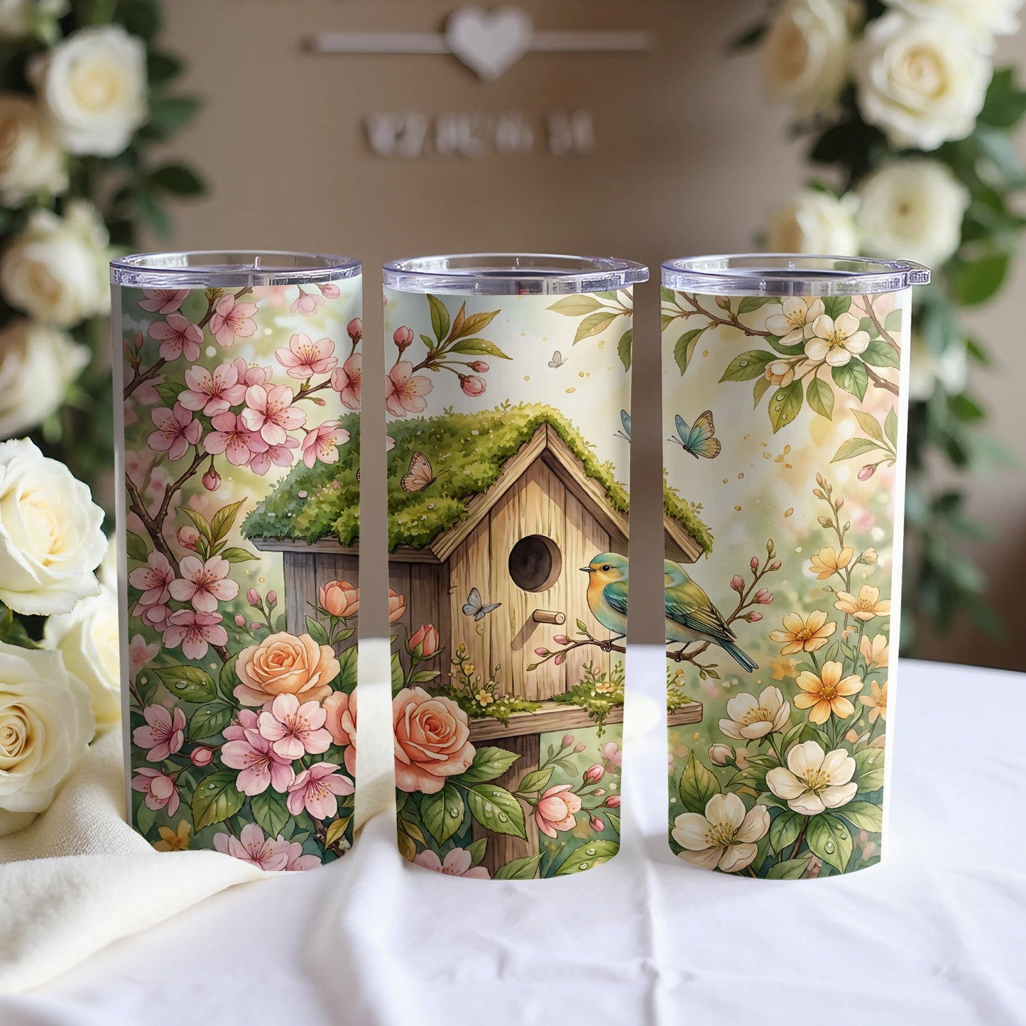 Three floral tumblers with birdhouses and butterflies.