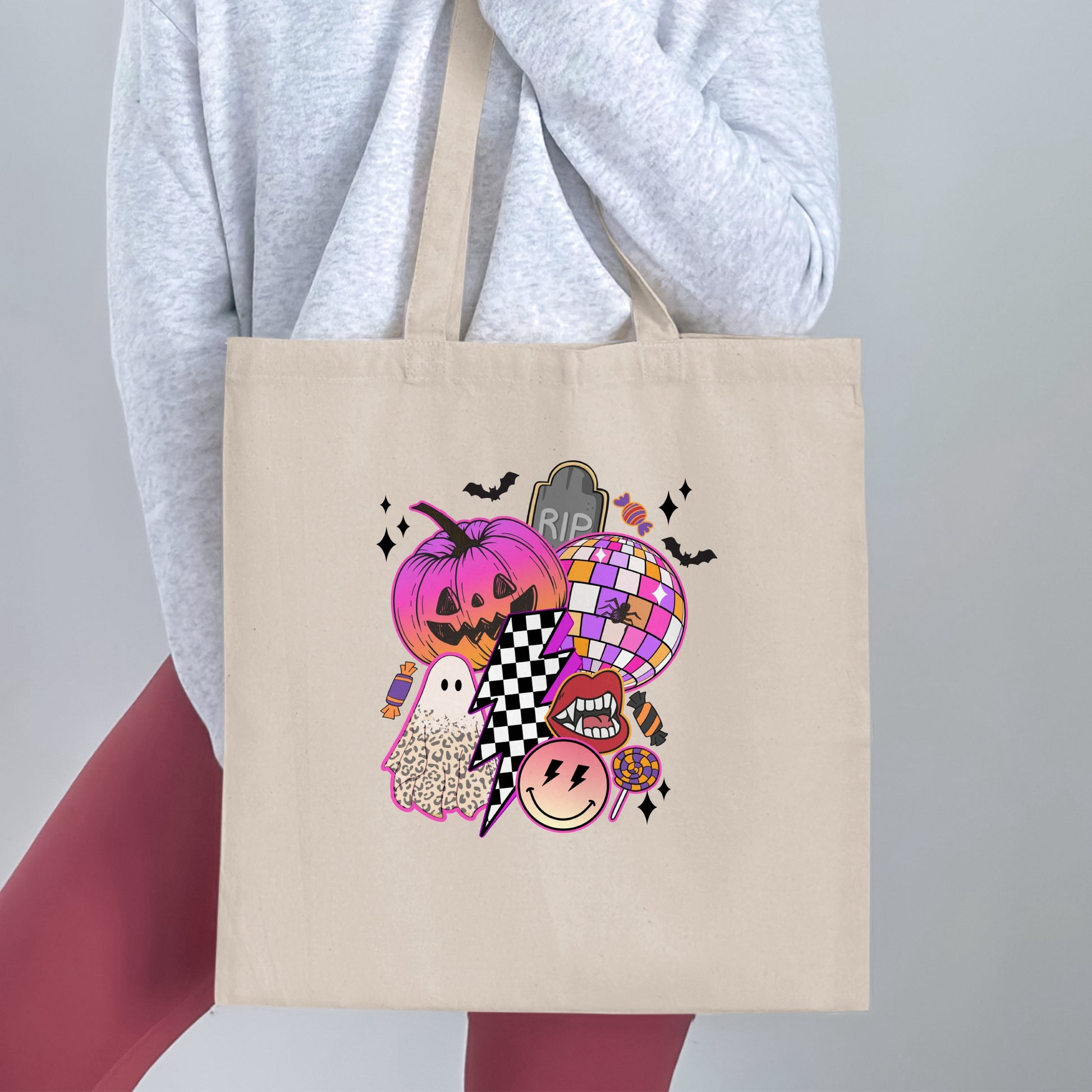 Tote bag with Halloween graphic featuring pumpkin, ghost, disco ball, eyes, and candy.