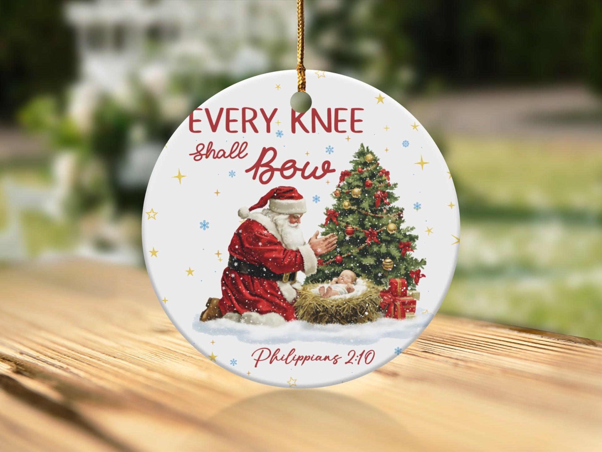Ornament with Santa kneeling before baby Jesus, text "EVERY KNEE shall Bow" and "Philippians 2:10".