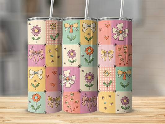 Patchwork design with flowers and bows on a tumbler with straw.