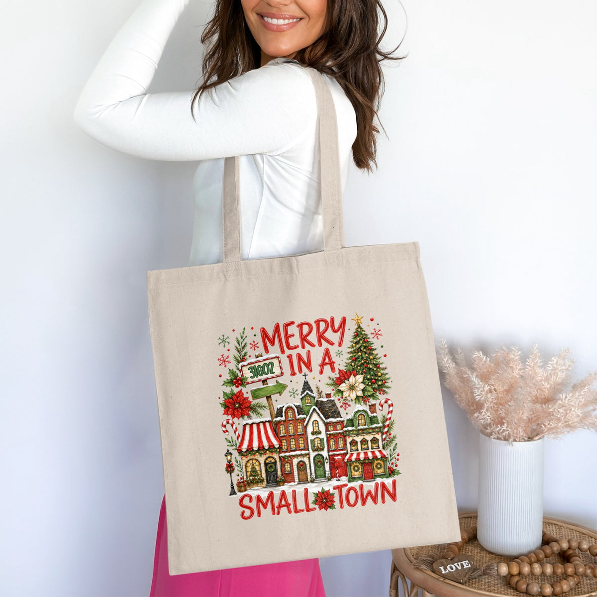 Tote bag with Christmas village graphic and "Merry in a Small Town" text.