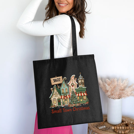 Black tote bag with "Small Town Christmas" and a snowy village graphic.