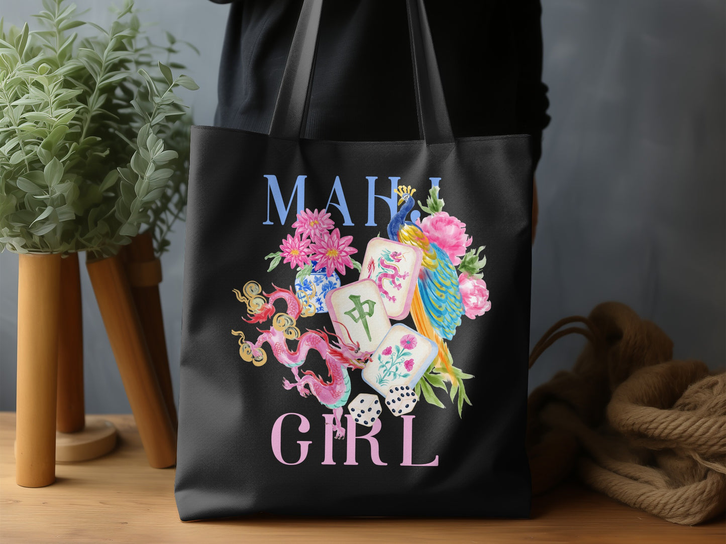 Black tote bag with "MAHI GIRL" and watercolor art of mahjong tiles, dragons, and a peacock.