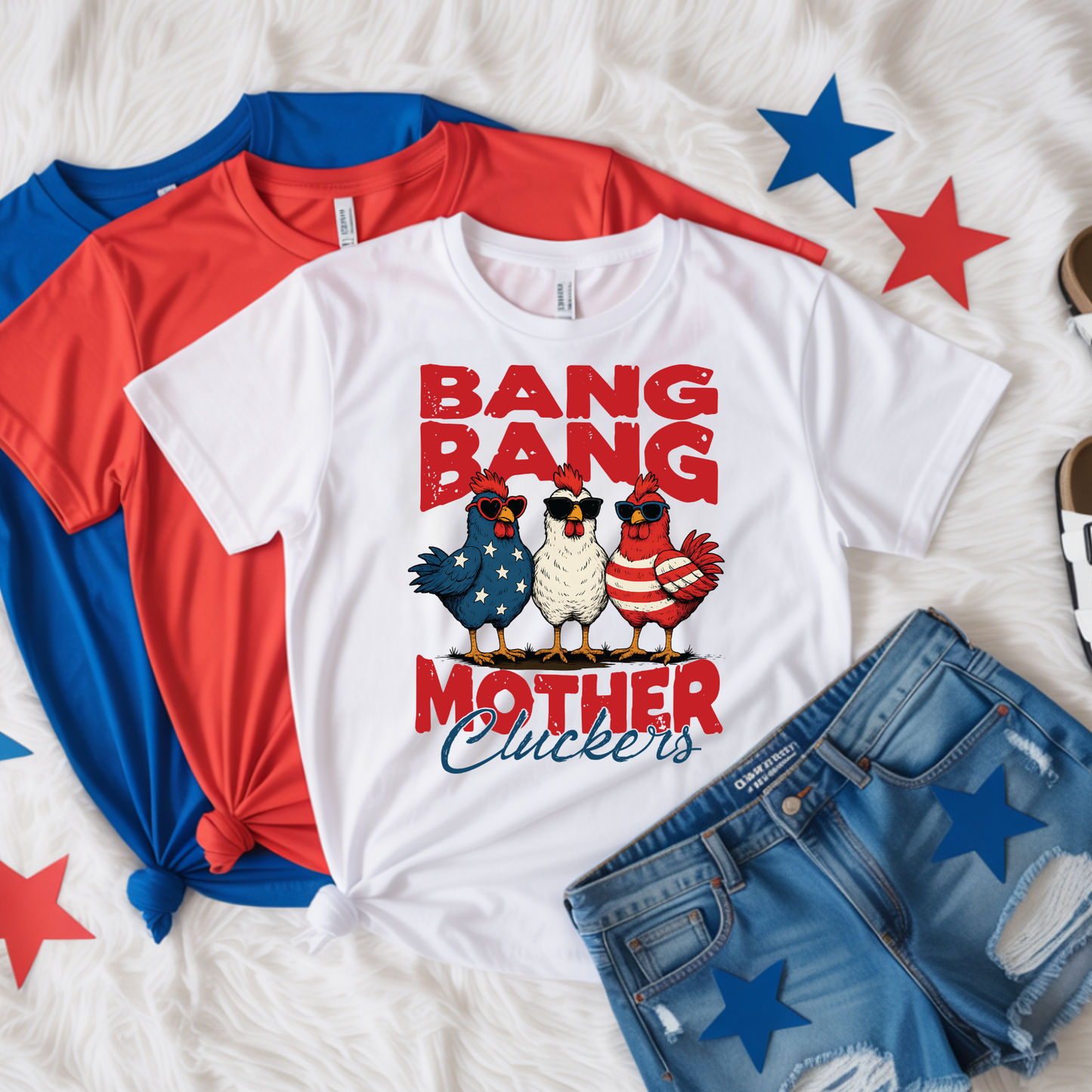 White t-shirt with 'Bang Bang Mother Cluckers' design, surrounded by red and blue shirts and denim shorts on a white background with star decorations.