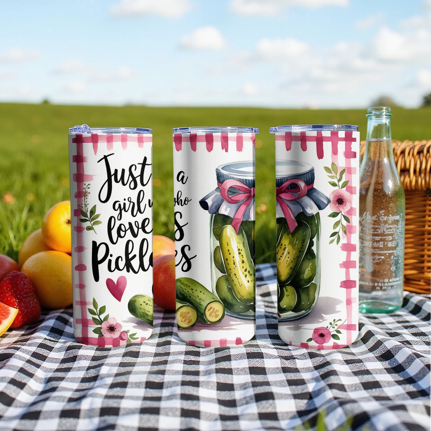 Three tumblers with "Just a girl who loves pickles" text and pickle graphics on picnic blanket.