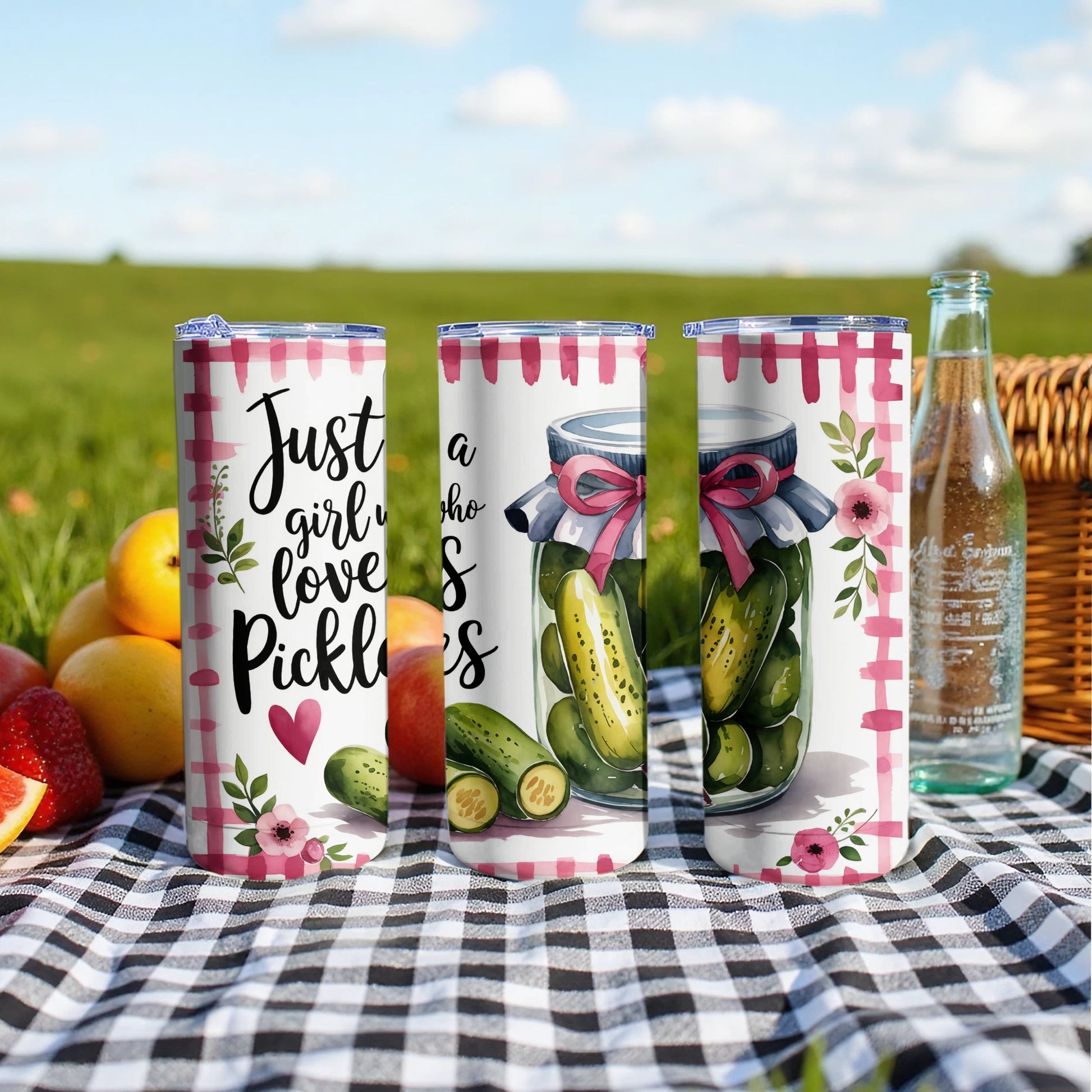 Three tumblers with "Just a girl who loves pickles" text and pickle graphics on picnic blanket.