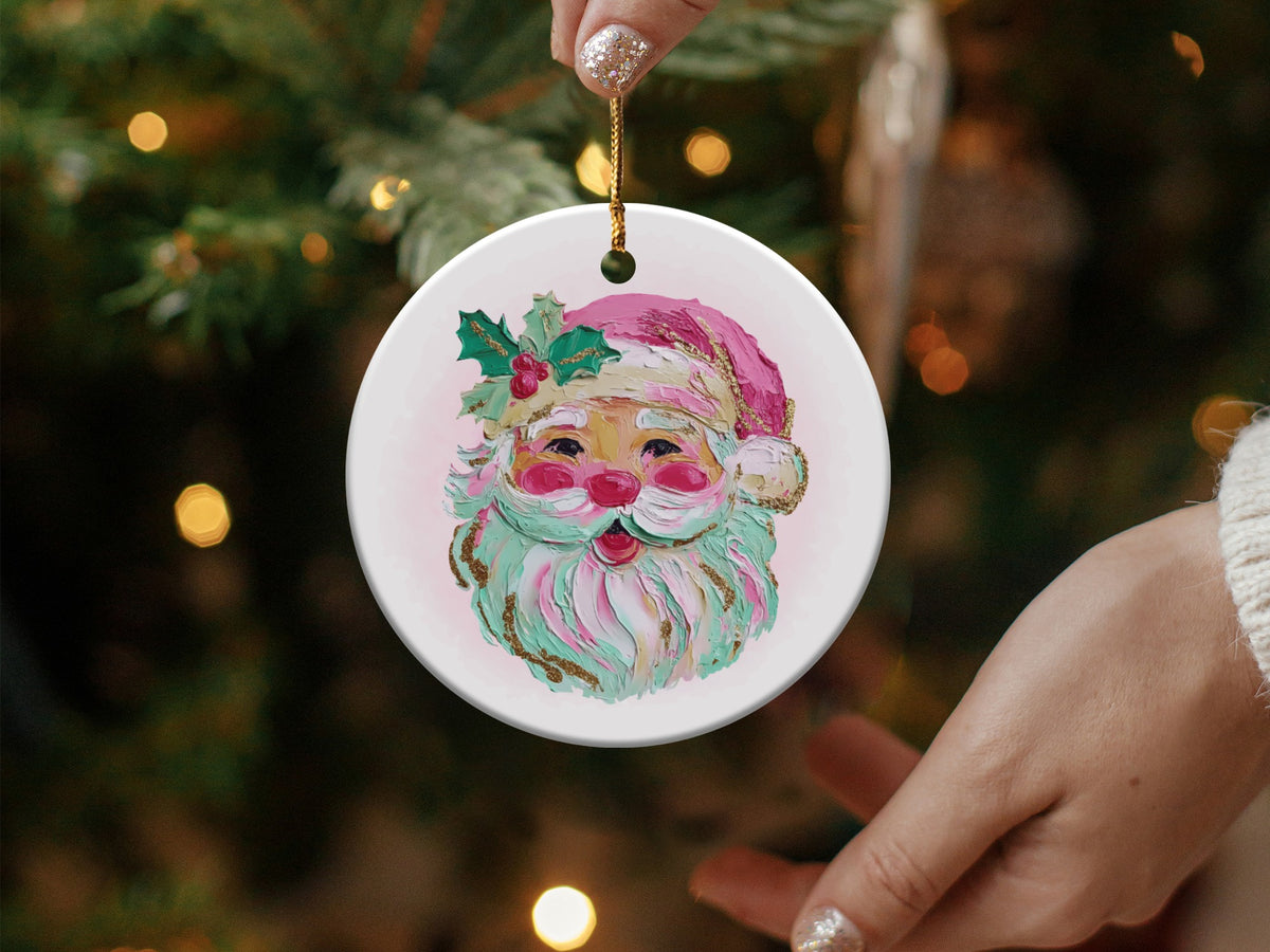 Round ornament with painted Santa face, holly, and sparkling gold accents.