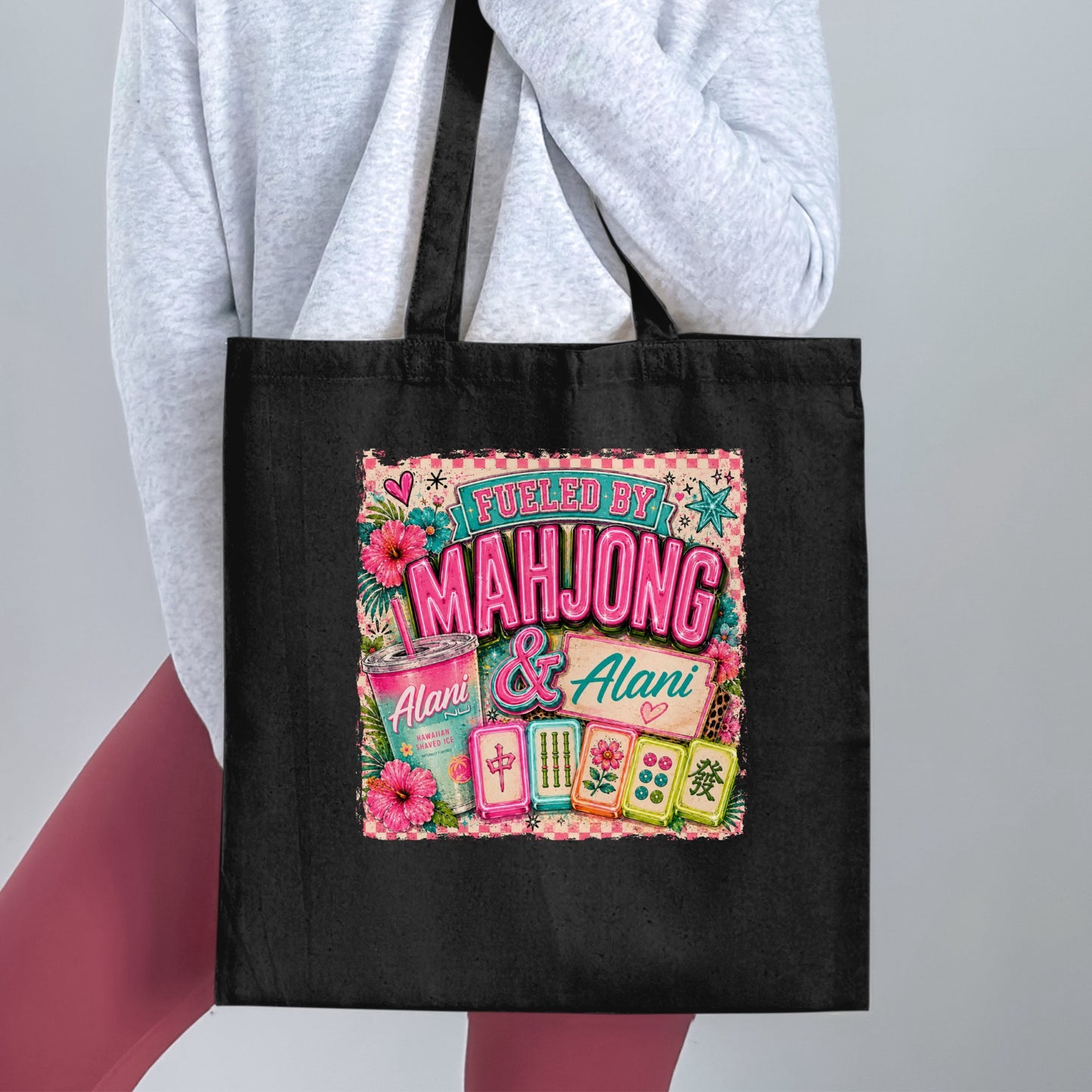 Black tote bag with "Fueled by Mahjong & Alani" graphic and Alani shaved ice cup.