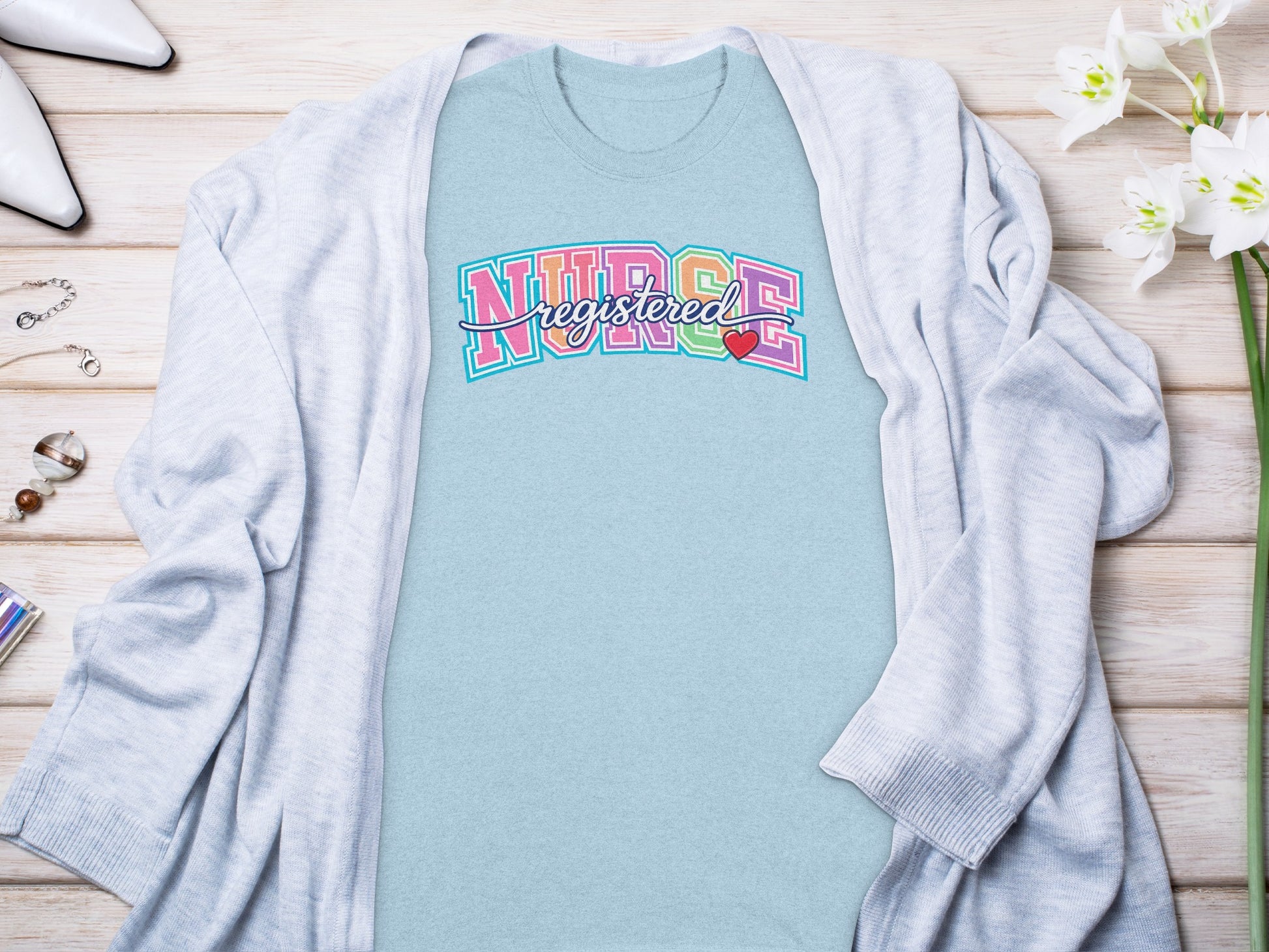 Light blue t-shirt with "Registered Nurse" in colorful pastel block lettering.