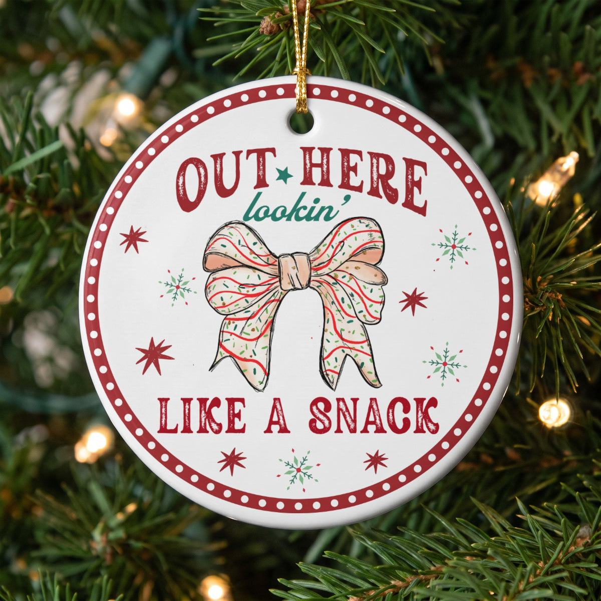 Round ornament with "OUT HERE lookin' LIKE A SNACK" and a bow.