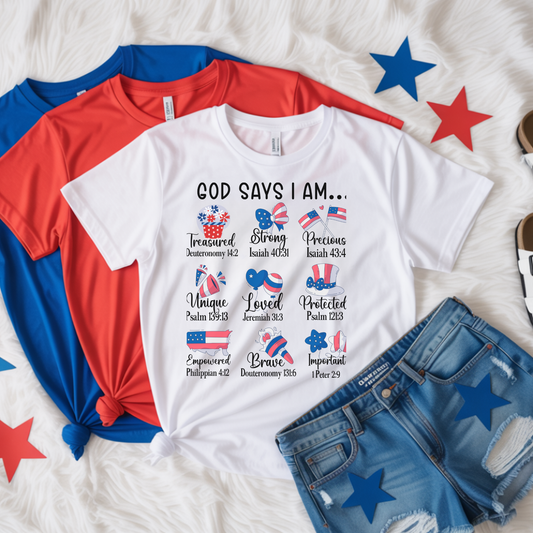 White t-shirt with christian text and graphics on a bed with red, blue, and white clothing items.