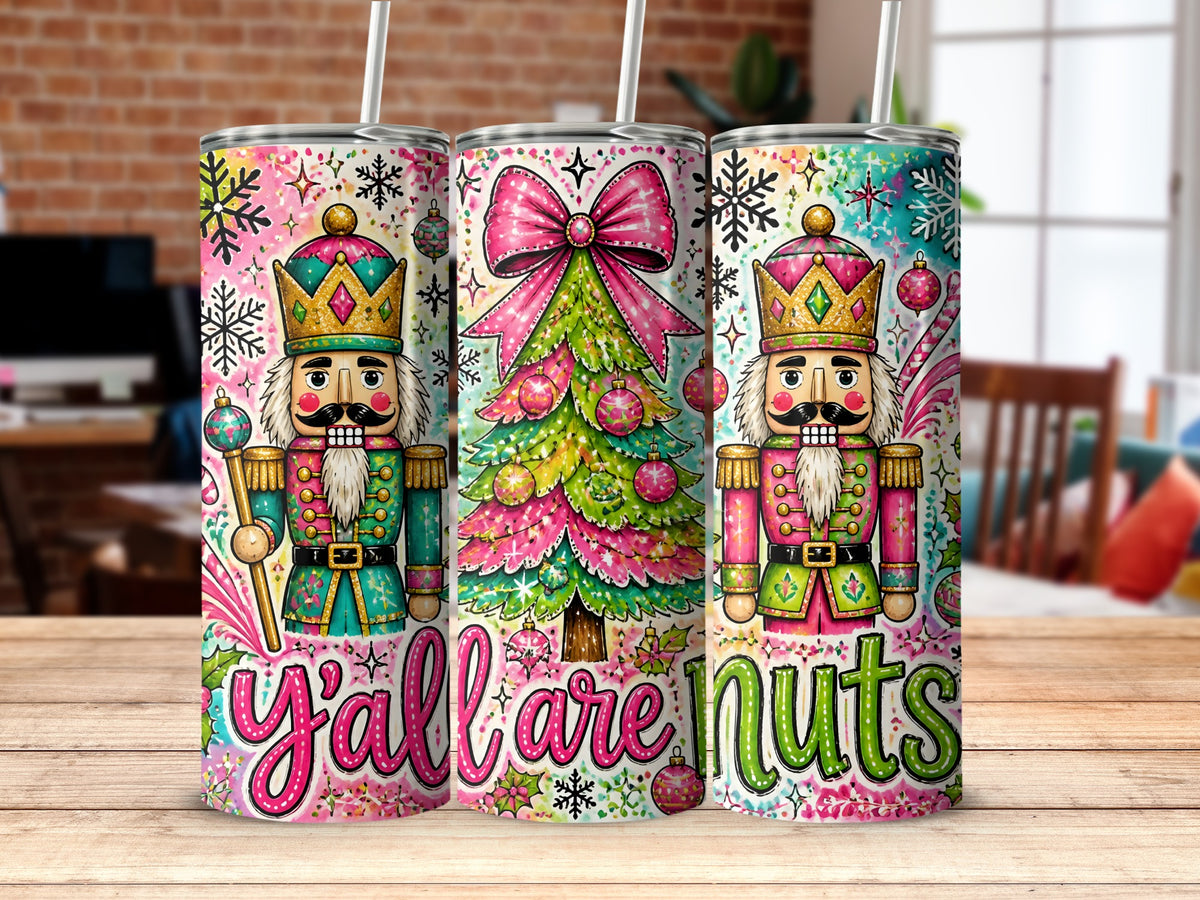 Three stainless steel tumblers feature a colorful Christmas pattern with nutcrackers, decorated trees, snowflakes, and the text y all are nuts.