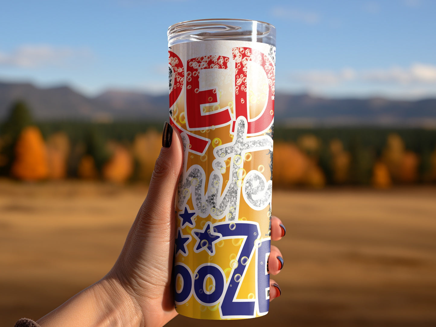 Hand holding a tumbler with "RED" and "BOOZE" text and star designs.