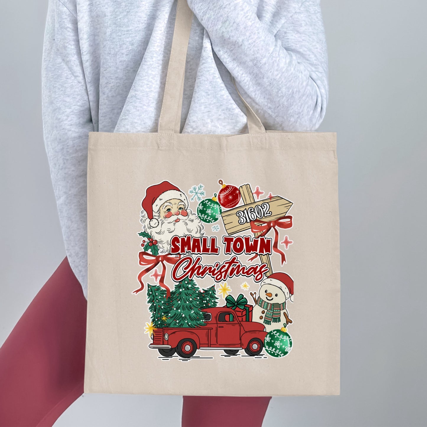 Tote bag with Santa, snowman, red truck, Christmas tree, and "Small Town Christmas" text.