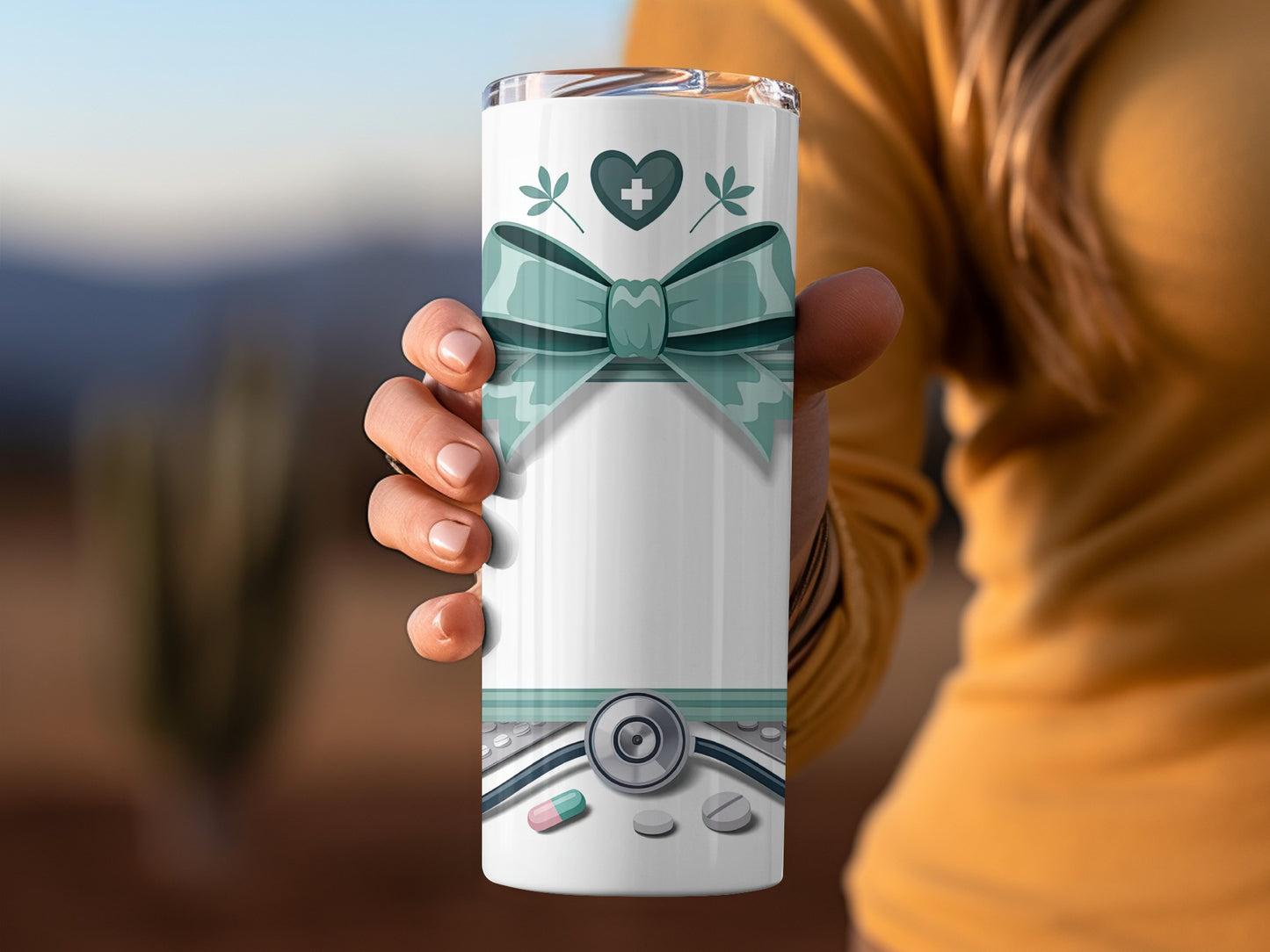 White tumbler with teal bow, stethoscope, pills, and heart symbol.