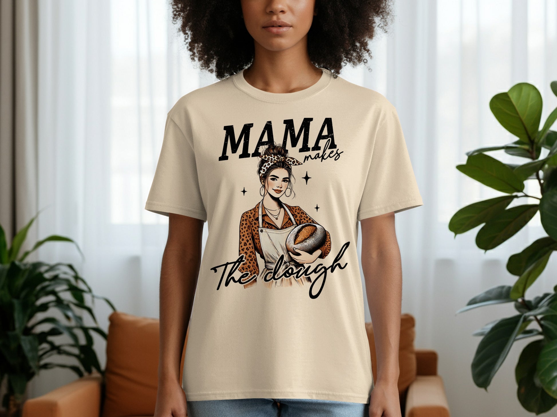 Woman wearing a "Mama makes the dough" t-shirt holding a loaf of bread.