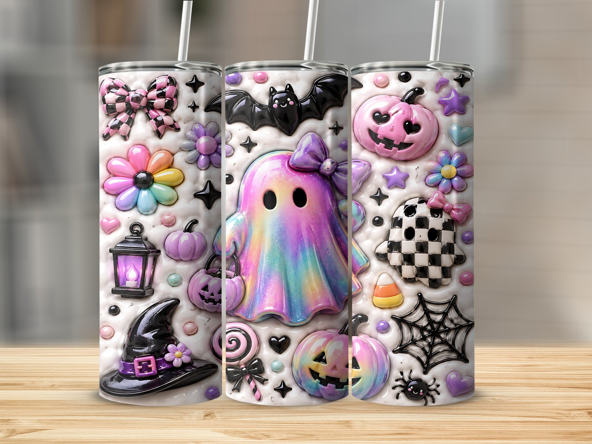 Three tumblers with Halloween-themed designs including ghosts, pumpkins, and bats.