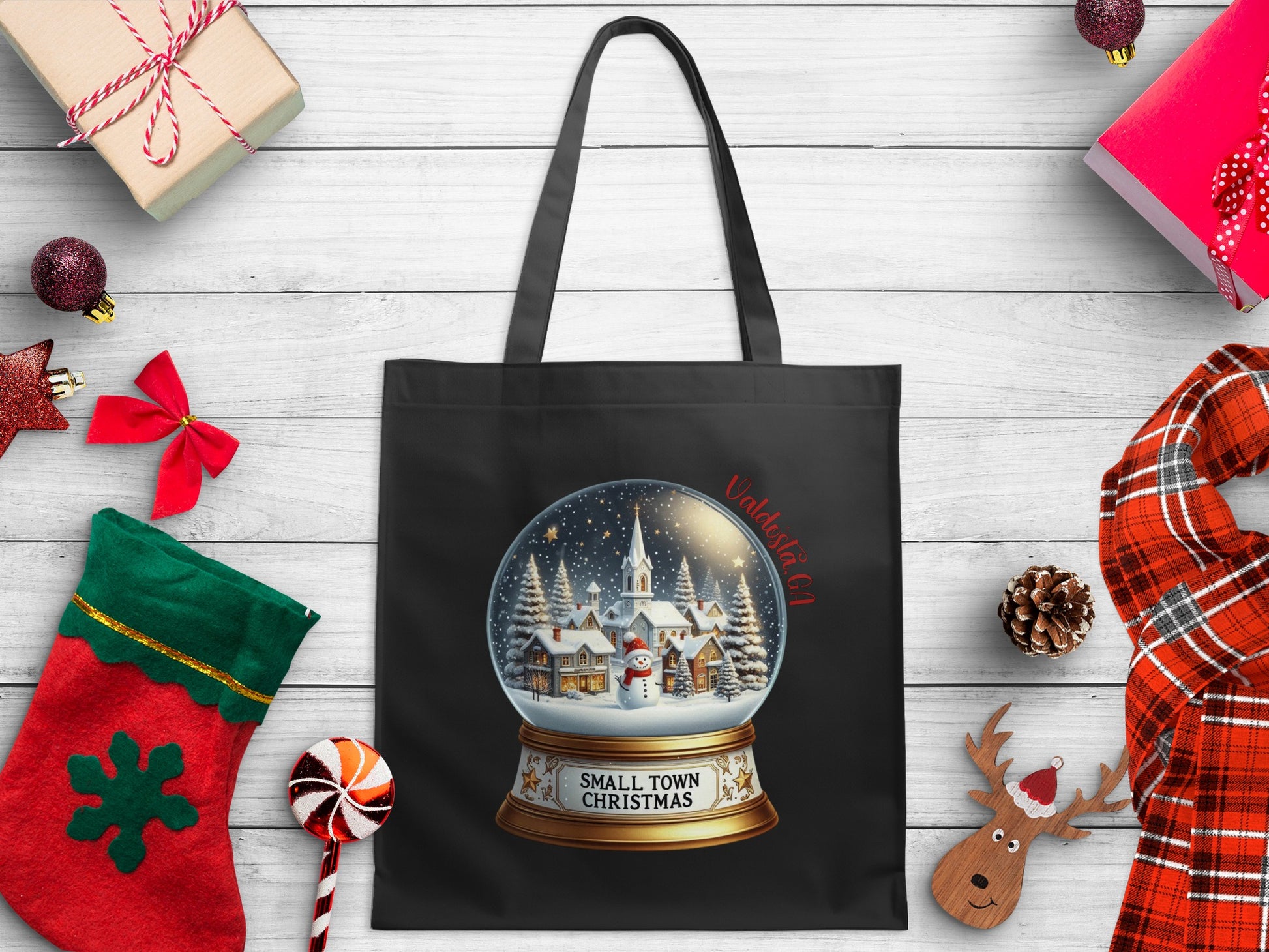 Black tote bag featuring a snow globe with a small town, snowman, and text "Valdosta GA".