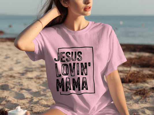Woman wearing a pink t-shirt with "JESUS LOVIN' MAMA" printed on it.