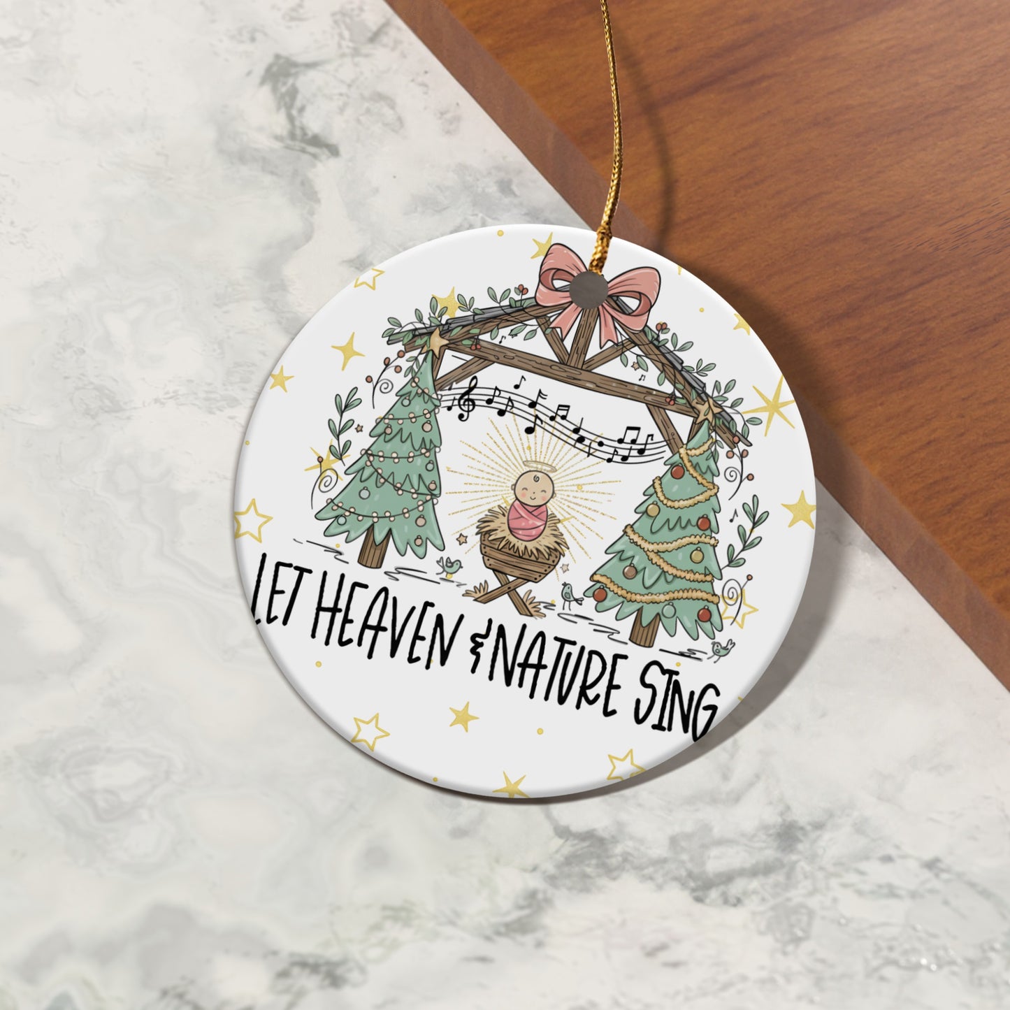 Christmas ornament with Nativity scene, trees, and "Let Heaven & Nature Sing" text.