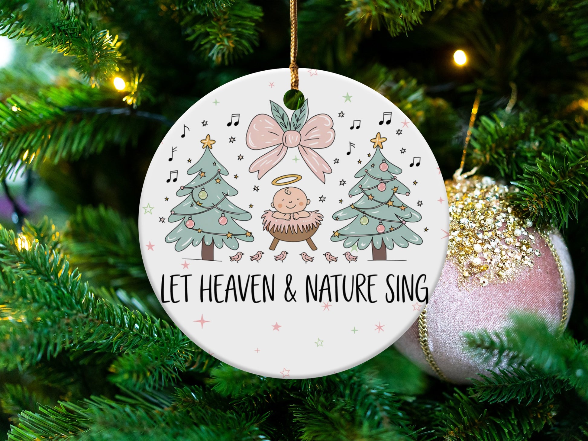 Ceramic ornament with baby Jesus, Christmas trees, and "Let Heaven & Nature Sing" text.