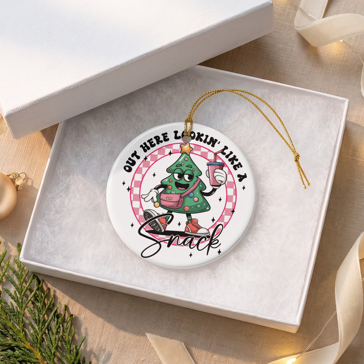Ornament featuring a cartoon Christmas tree with text "OUT HERE LOOKIN' LIKE A SNACK".