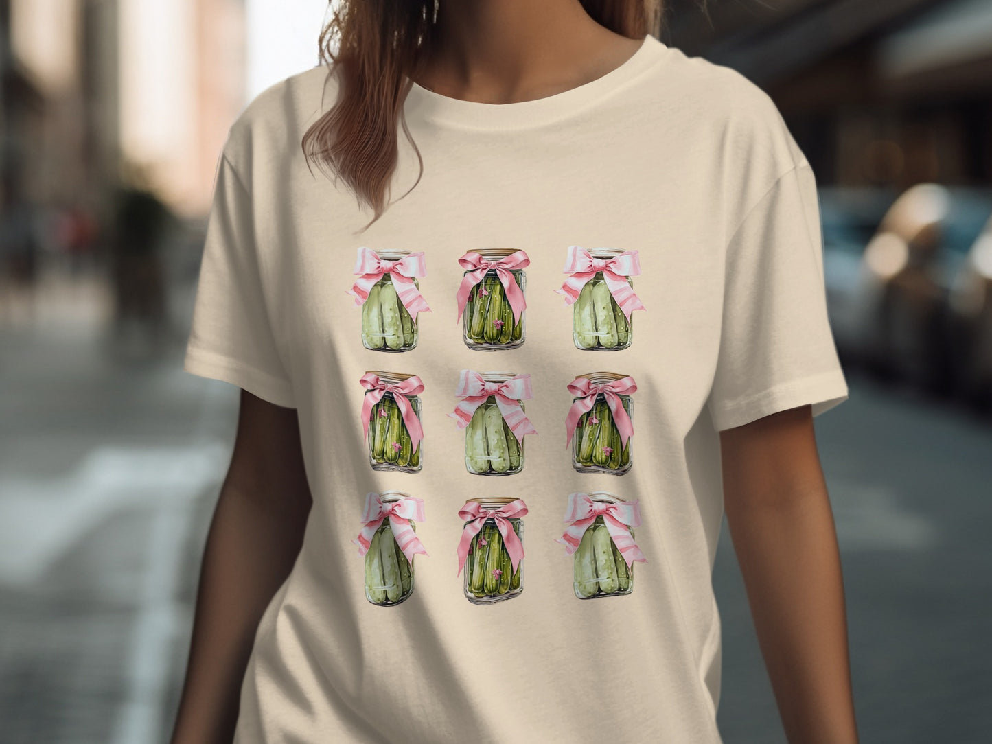 T-shirt with nine jars of pickles adorned with pink bows.