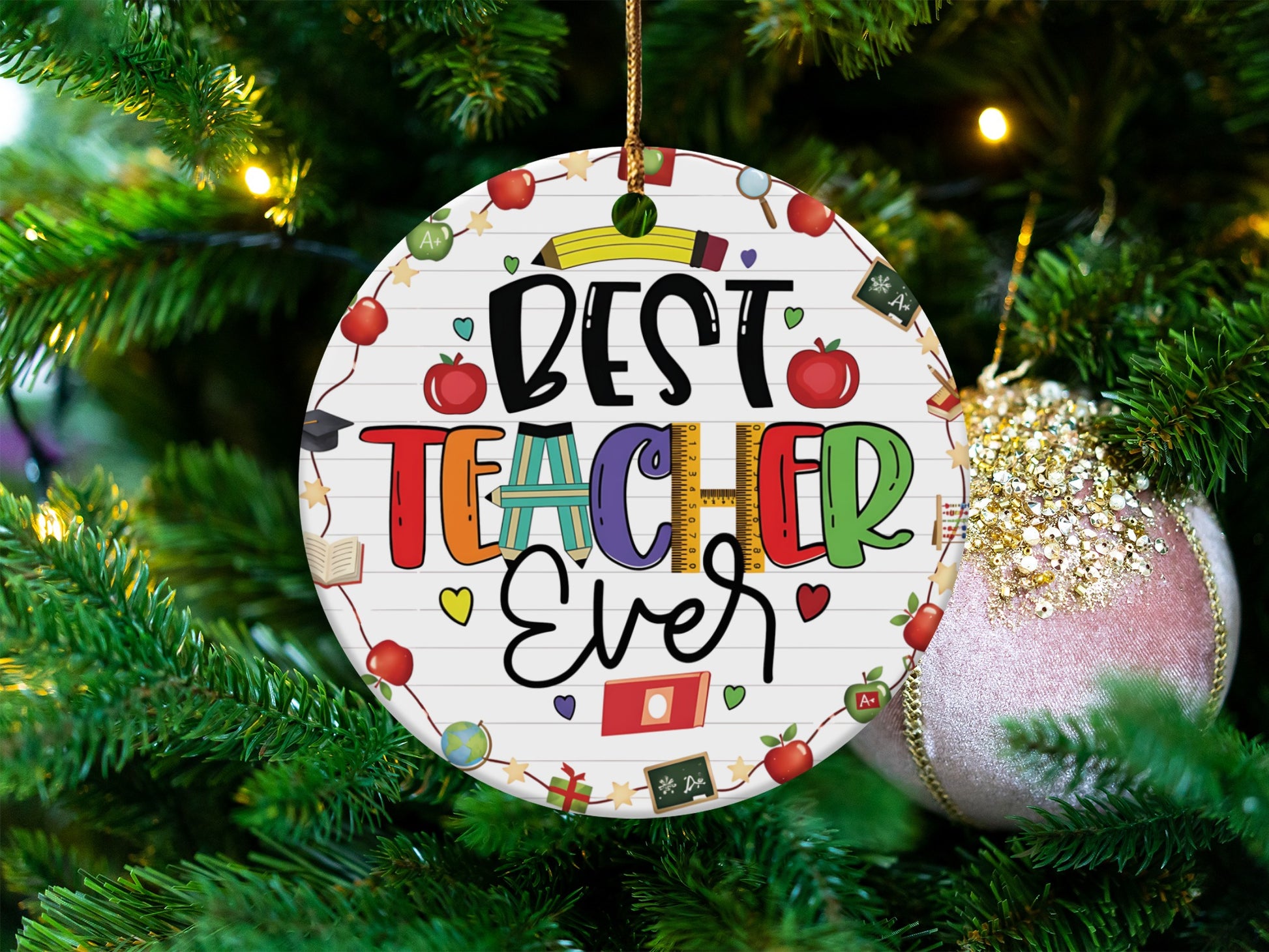 Round ornament with "Best Teacher Ever" and school-themed icons on a Christmas tree.