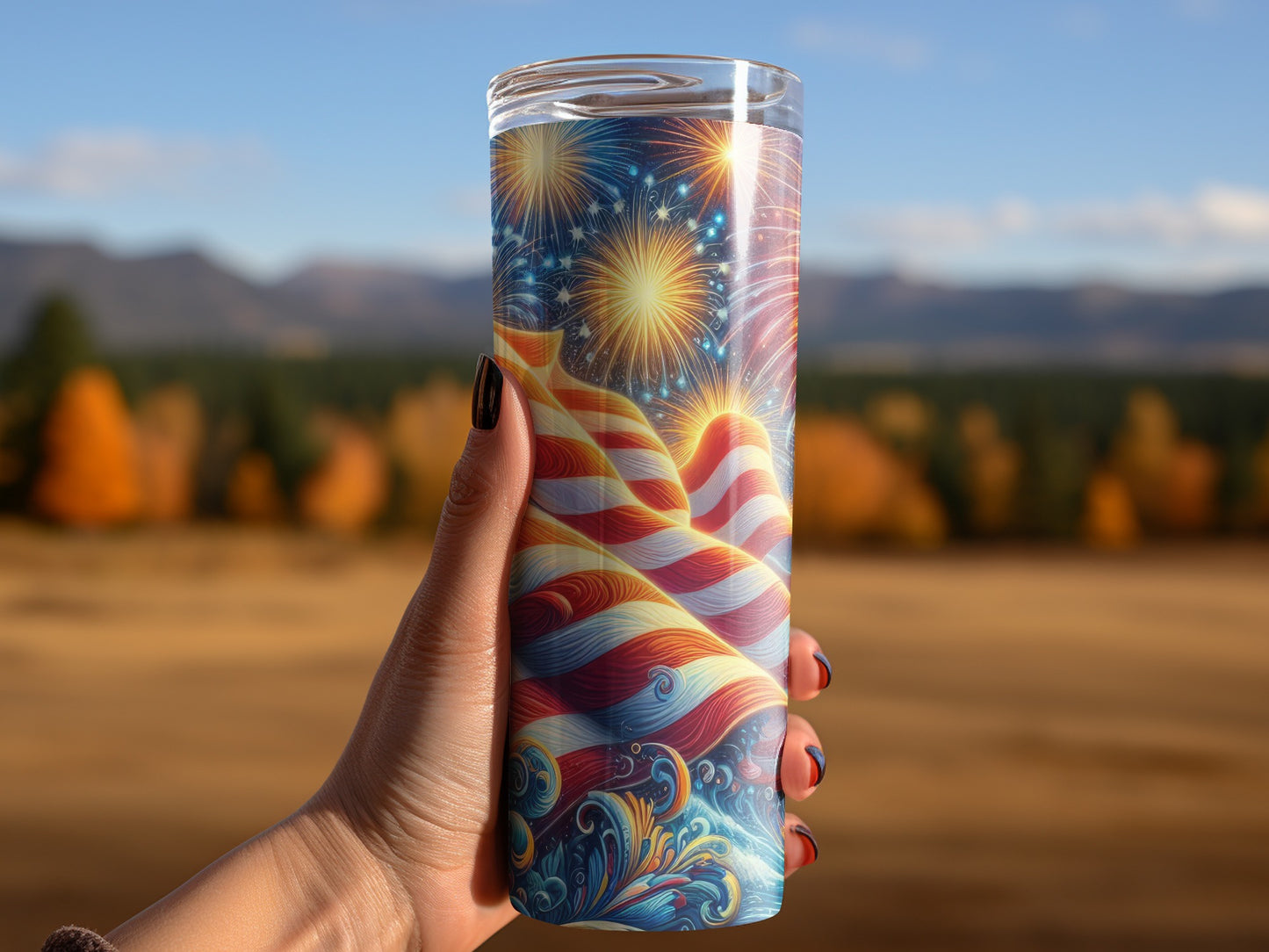 Tumbler with waving American flag and fireworks design held by a hand.