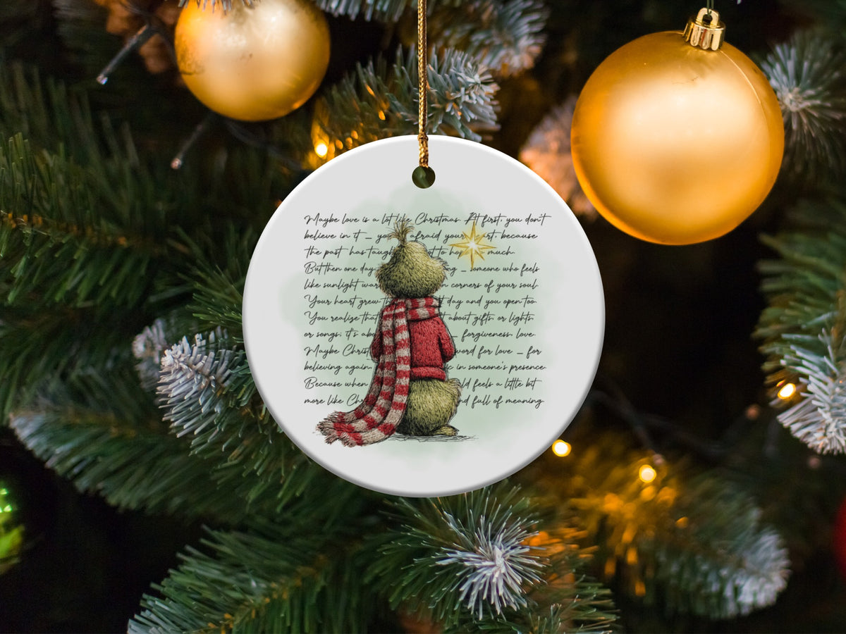 Round Christmas ornament with a bear illustration and handwritten text about love.
