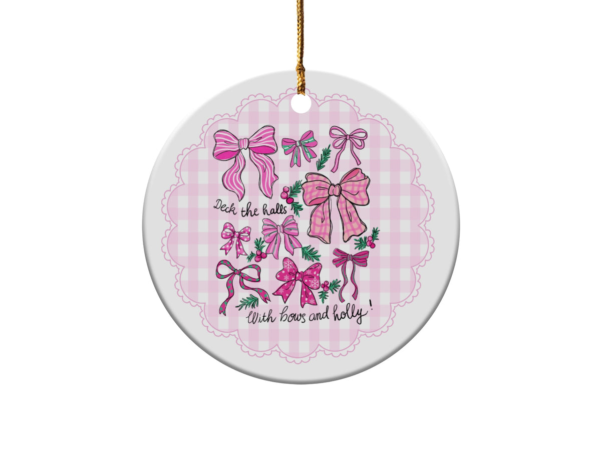 Round ceramic ornament with pink bows and holly, reads "Deck the halls".
