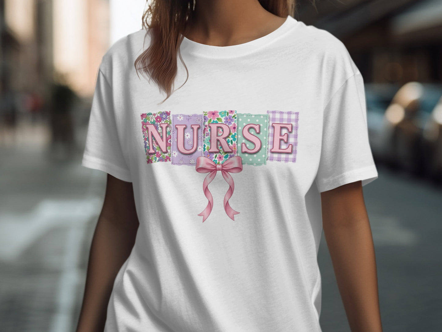 White t-shirt with "NURSE" spelled out in pastel patchwork letters and a pink bow.