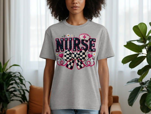 Grey t-shirt with "NURSE" text and a pink and blue checkered bow.