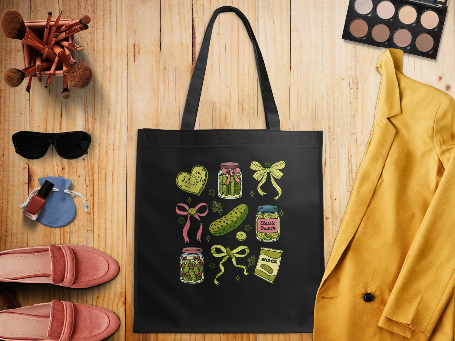 Black tote bag with nine colorful cartoon pickle jar and bow designs.