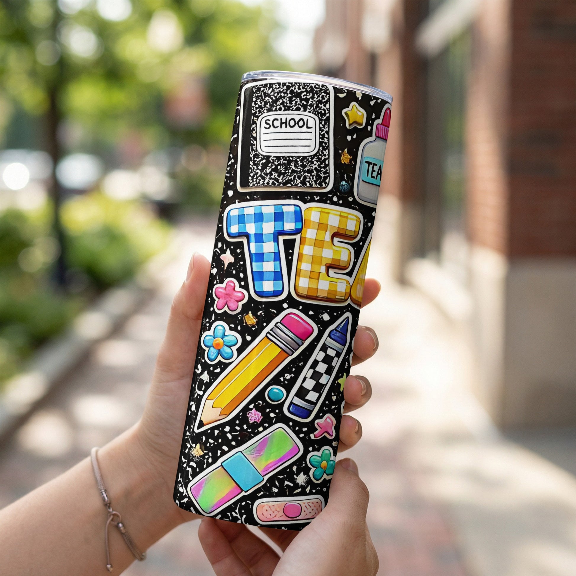 Black tumbler with school-themed stickers including "SCHOOL," "TEA," pencil, crayon, and flowers.