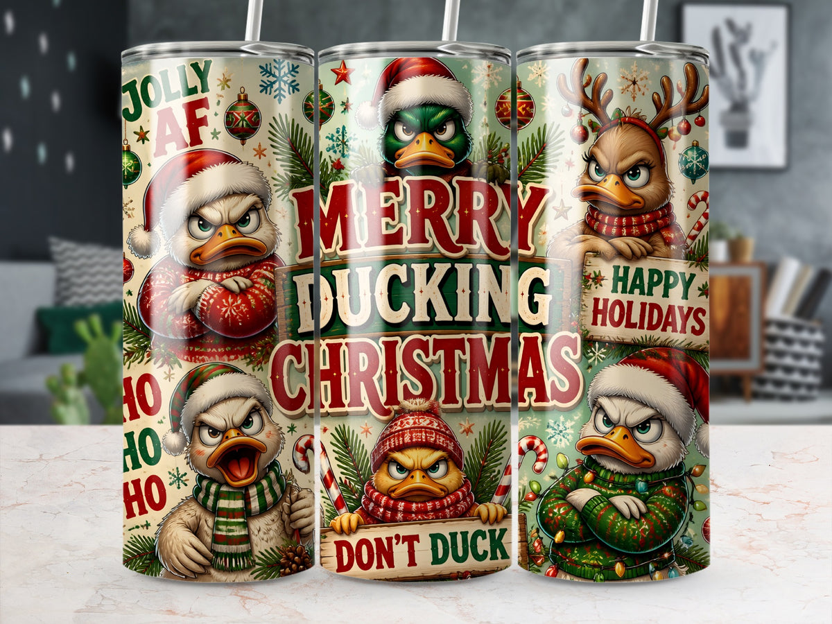 Three tall metal tumblers display a wrap-around design of grumpy, festive ducks wearing holiday sweaters, hats, and antlers amid Christmas motifs and humorous text.