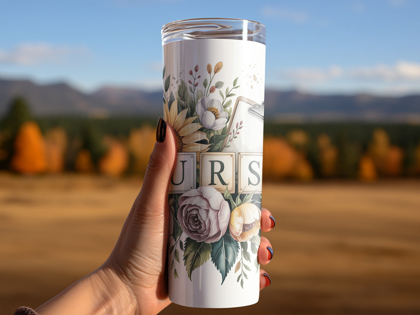 White tumbler with floral design and "URS" letters held by a hand.