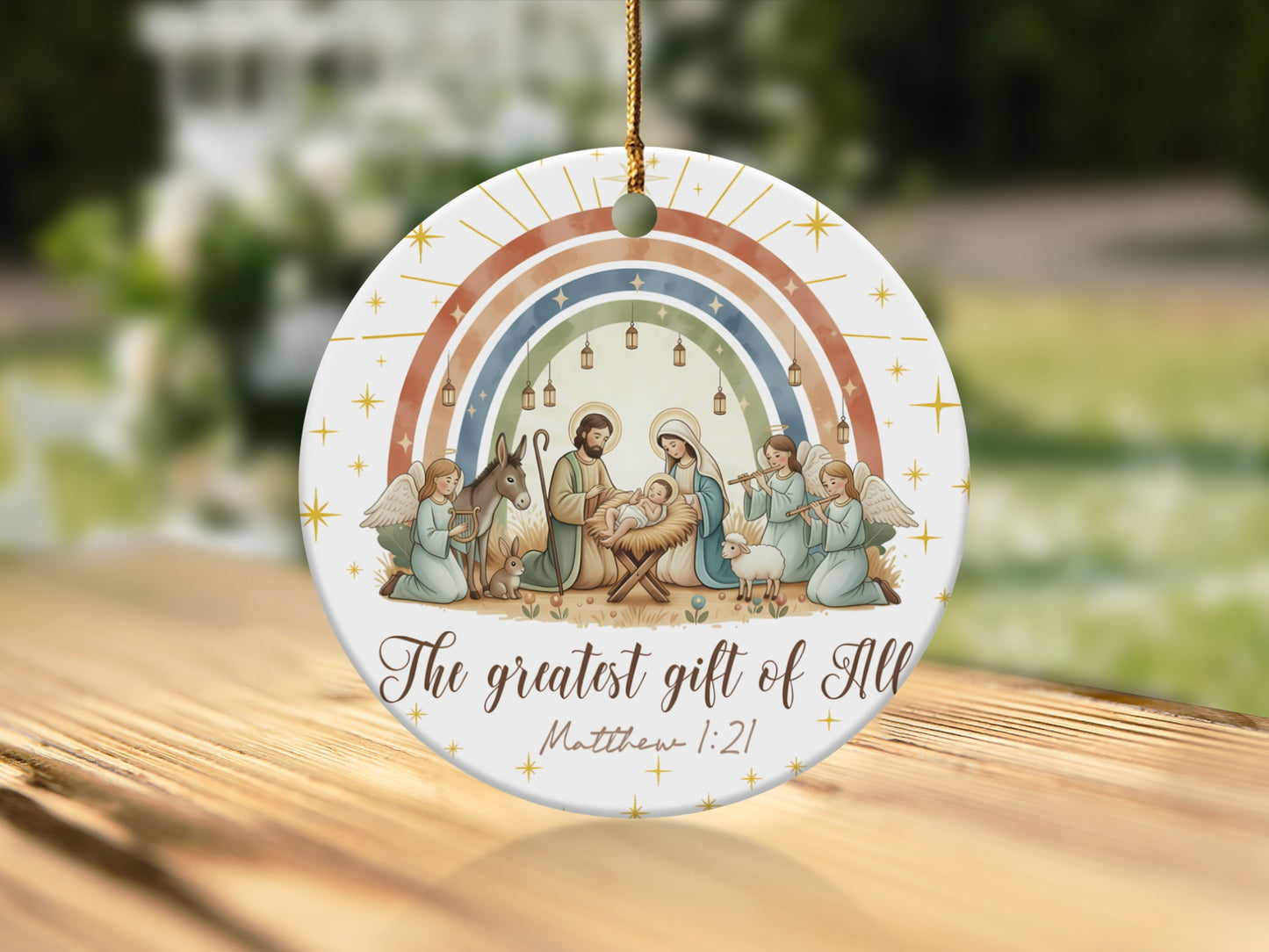 Nativity scene ornament with angels, animals, and rainbow, reads "The greatest gift of All Matthew 1:21".
