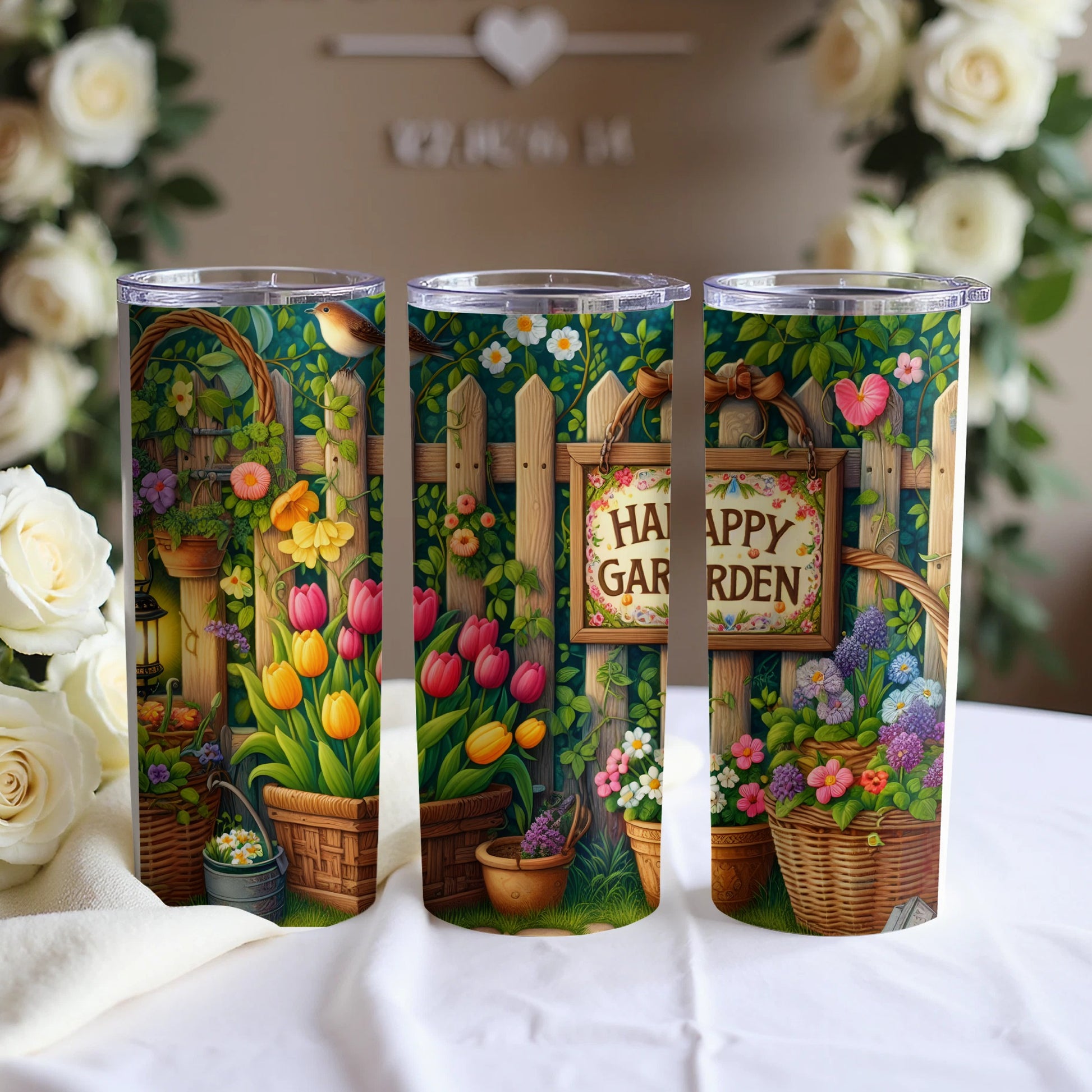 Three tumblers with a garden scene, fence, flowers, and "Happy Garden" sign.