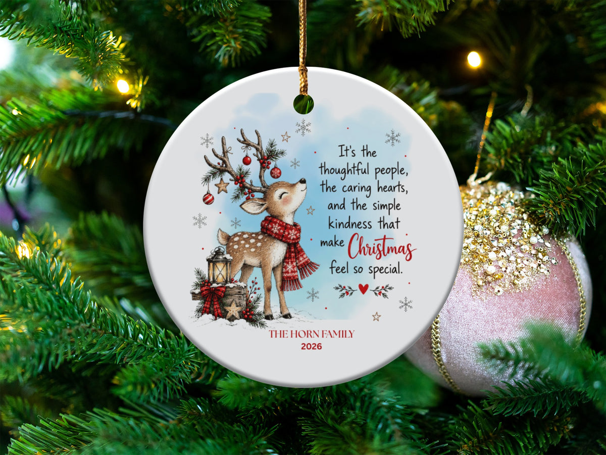 A round ceramic Christmas ornament featuring a cute reindeer, holiday quote, and customizable family name.