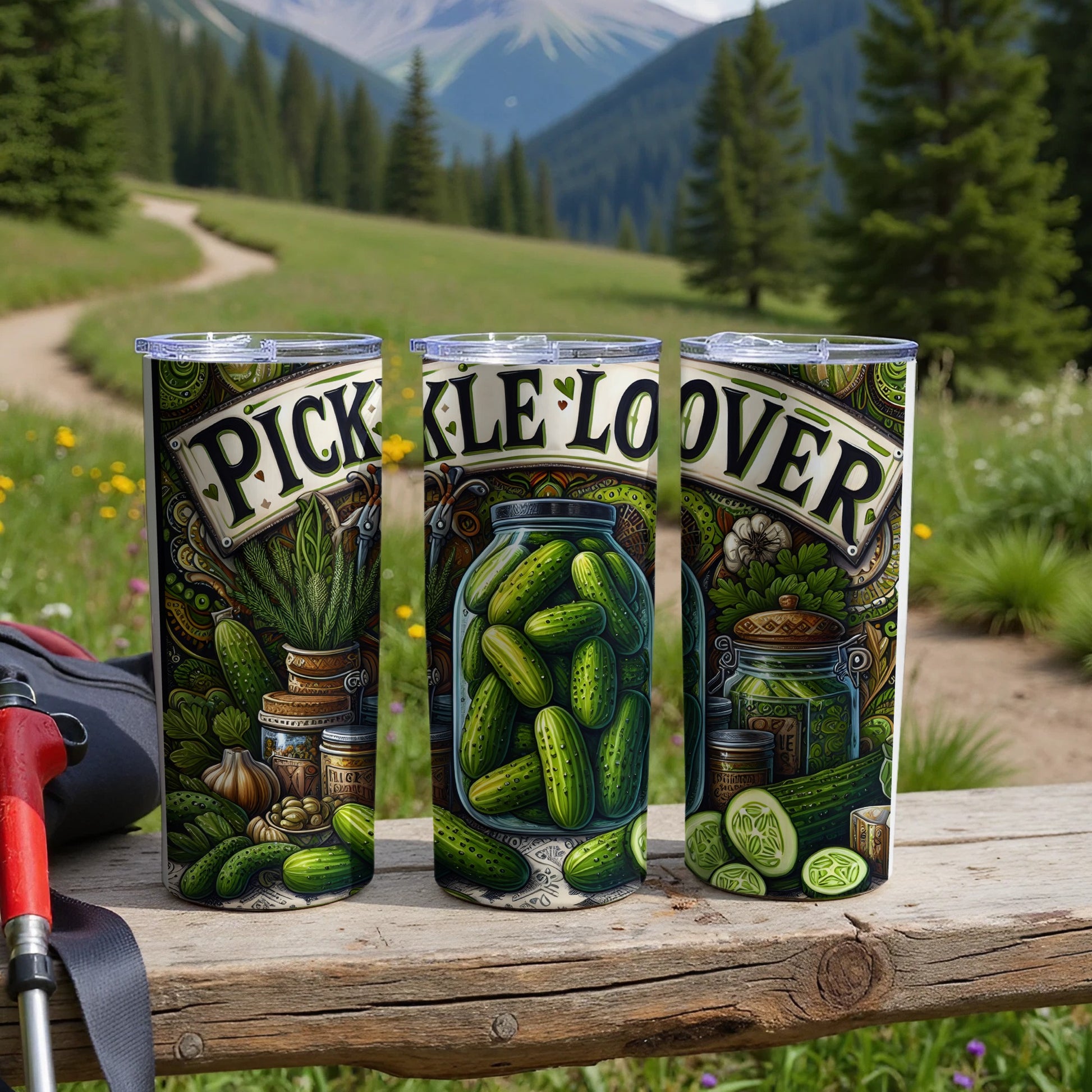 Three tumblers with pickle-themed art and "pickle lover" text in a scenic outdoor setting.
