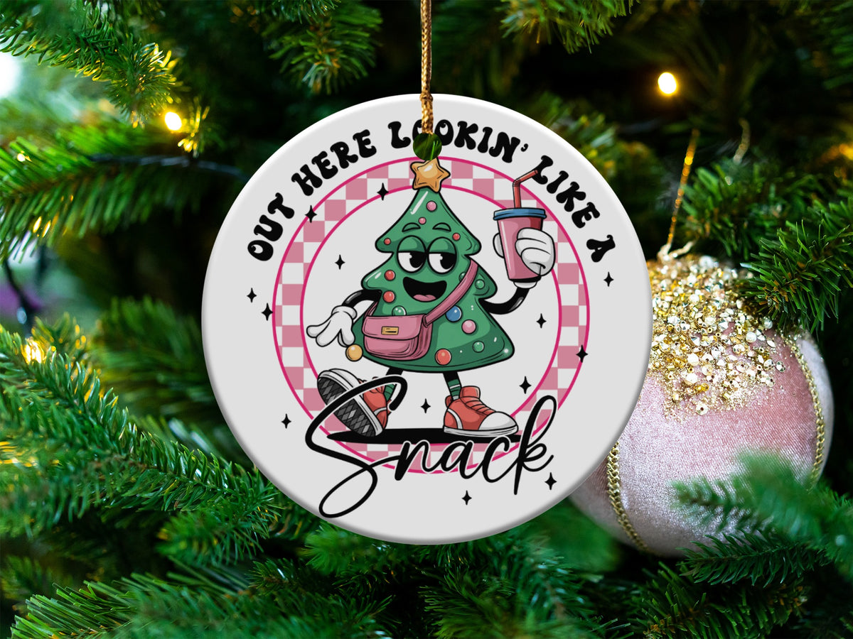 Christmas ornament with cartoon tree, holding drink, saying "Out Here Lookin' Like A Snack".