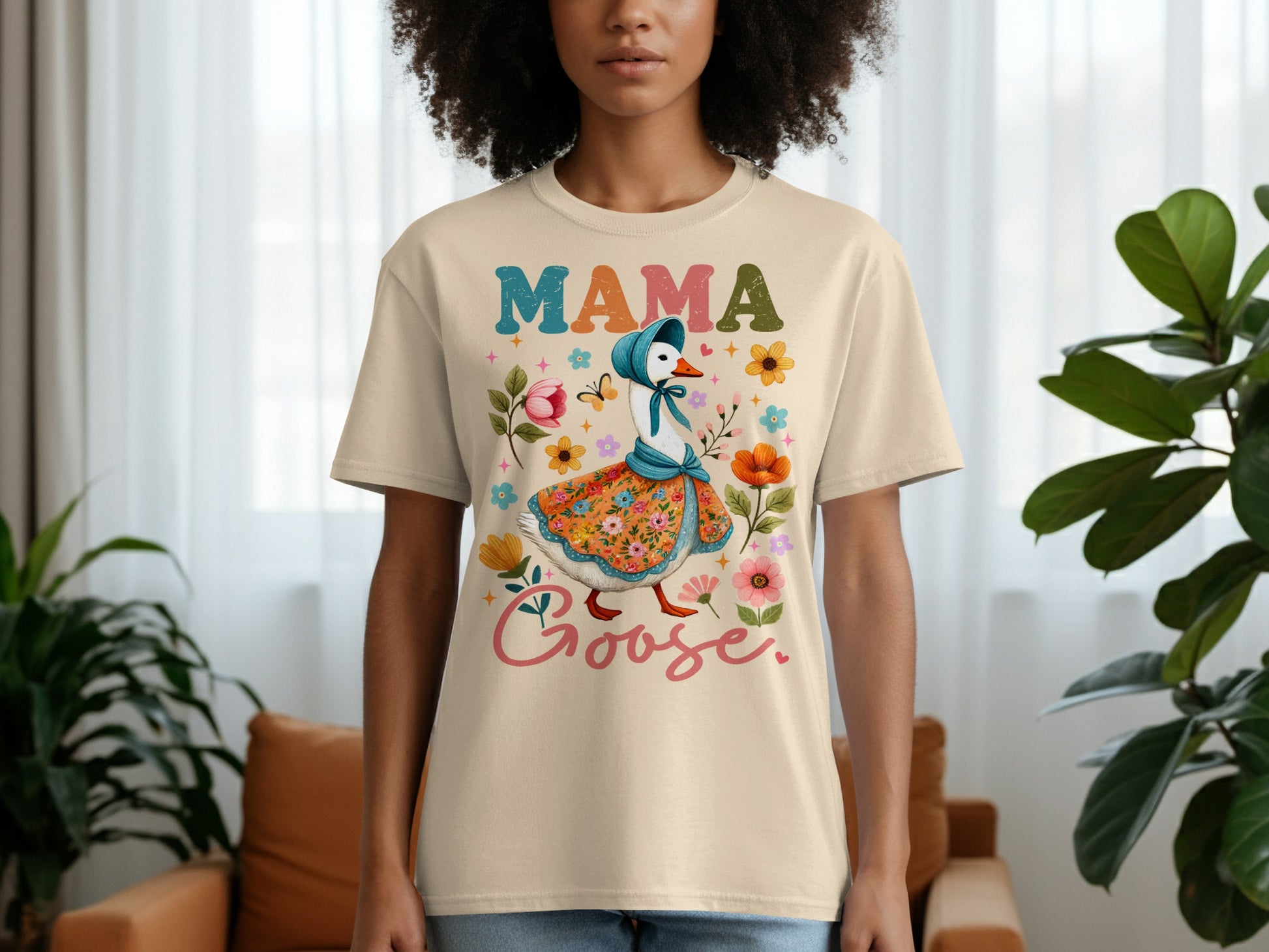 Cream t-shirt with colorful Mama Goose illustration and floral accents.